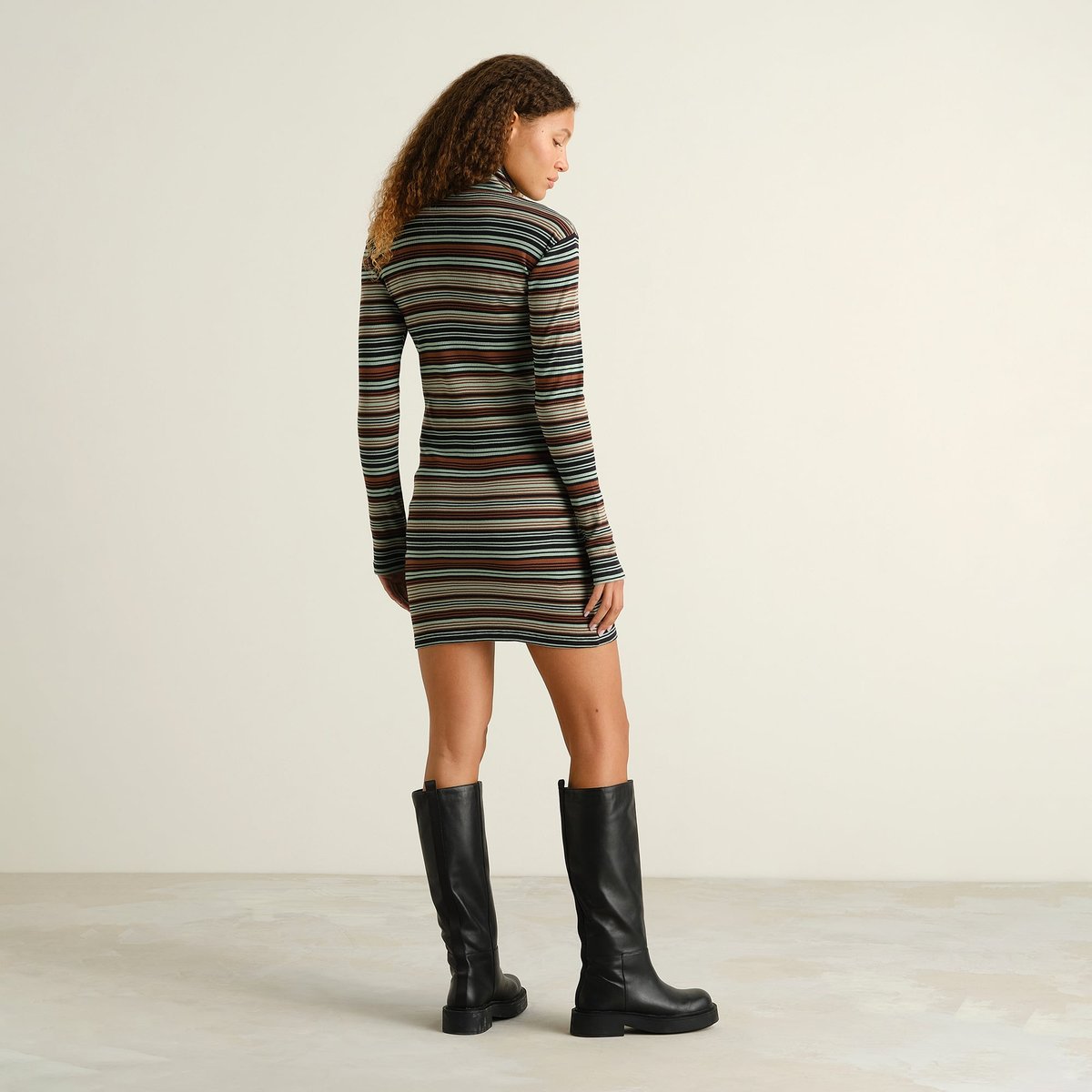 Effortless style from behind in the green striped Rib Dress Lunsen, perfectly paired with black boots.