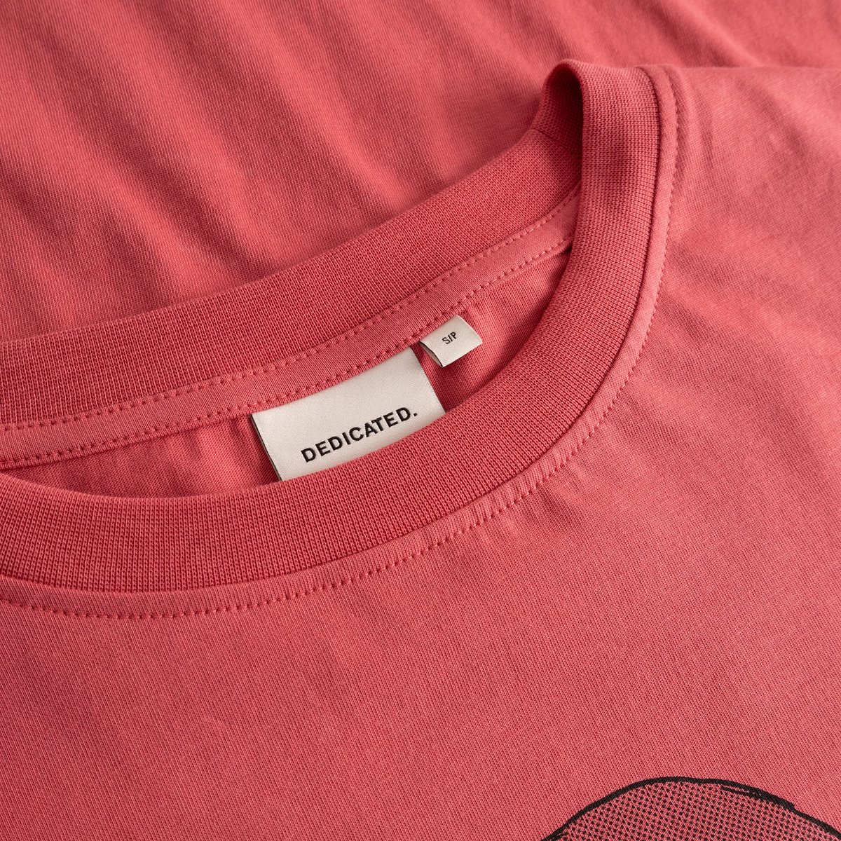 A close-up shot of the ribbed crew neck and brand label on the T-shirt Vadstena in Holly Red.