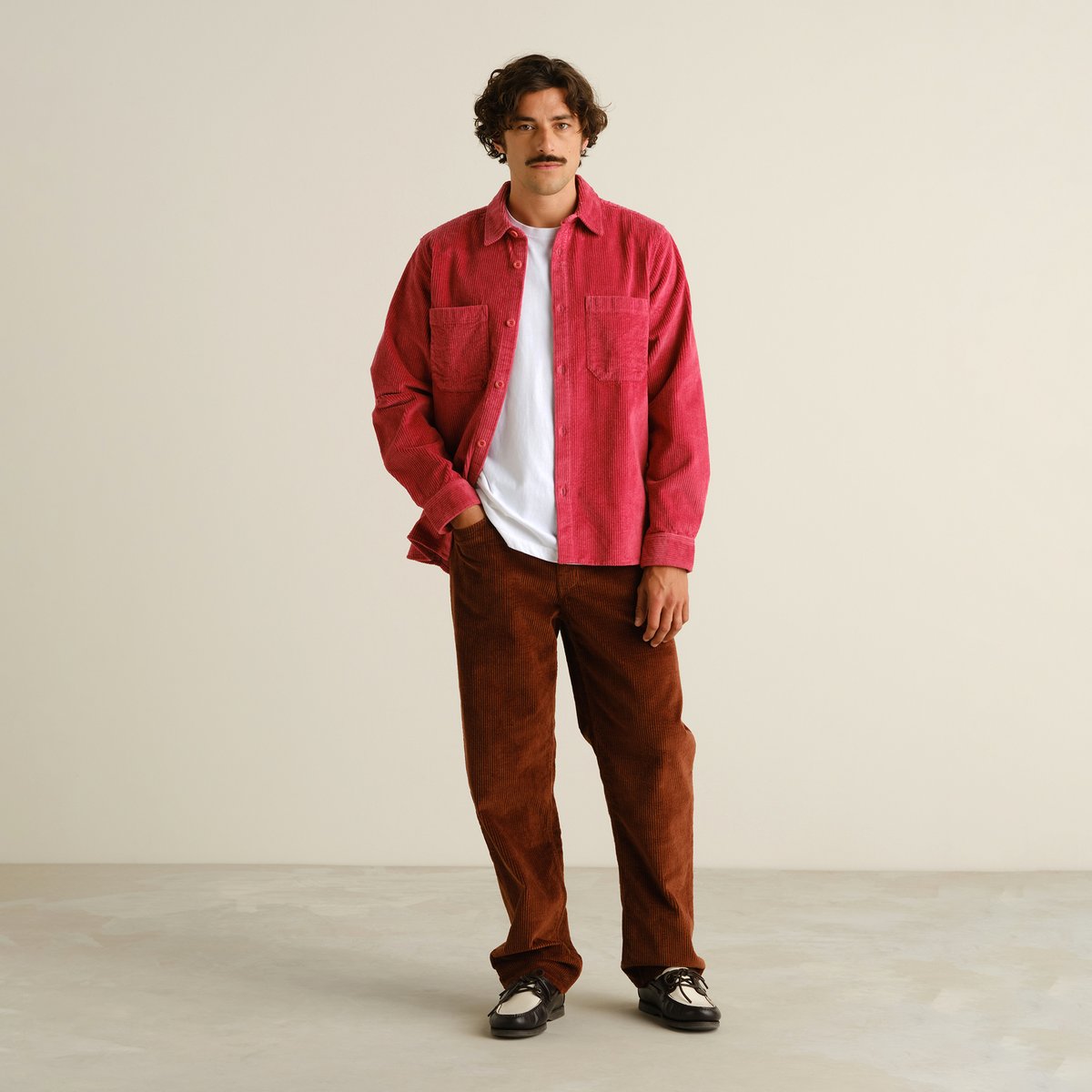 A model seen from the front, wearing the Shirt Kil Corduroy in Holly Red layered over a white t-shirt and brown pants.