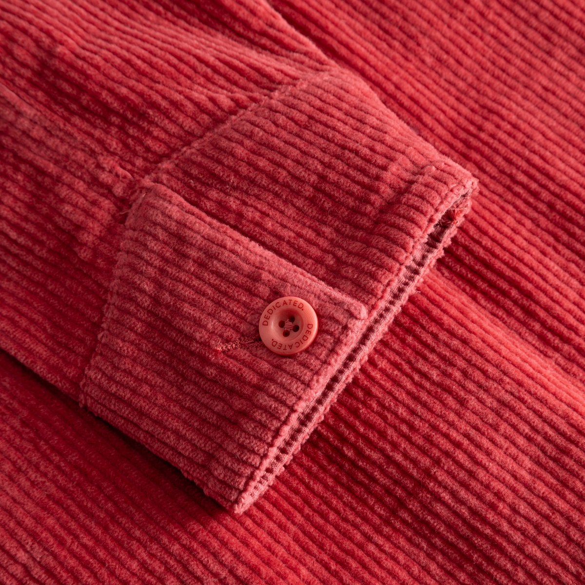 Close-up shot of the Holly Red corduroy sleeve on the Stiby Jacket, showing the cuff and branded button detail.