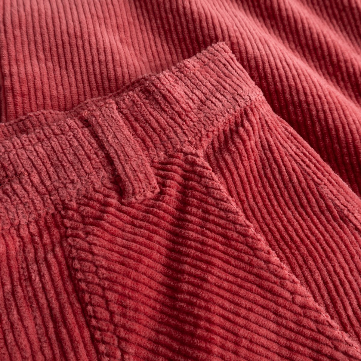 Close-up of the soft, ribbed corduroy fabric and waistband detail on the Vara Workwear Pants in Holly Red.