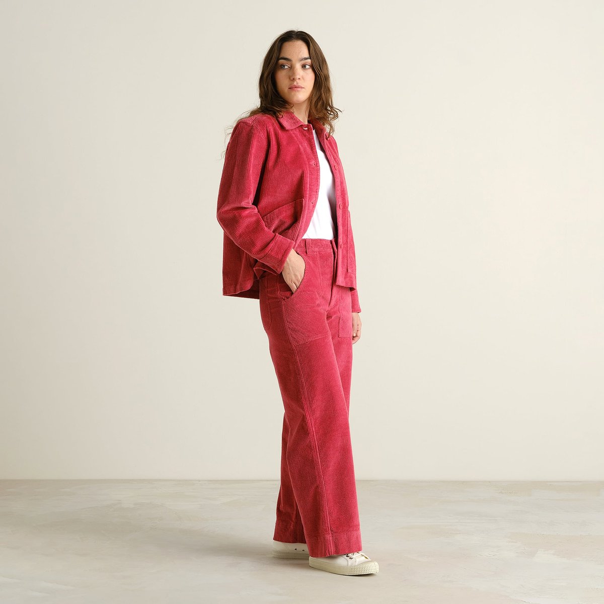 A woman in a studio models the complete Holly Red corduroy look, featuring the wide-leg Vara Workwear Pants and jacket.