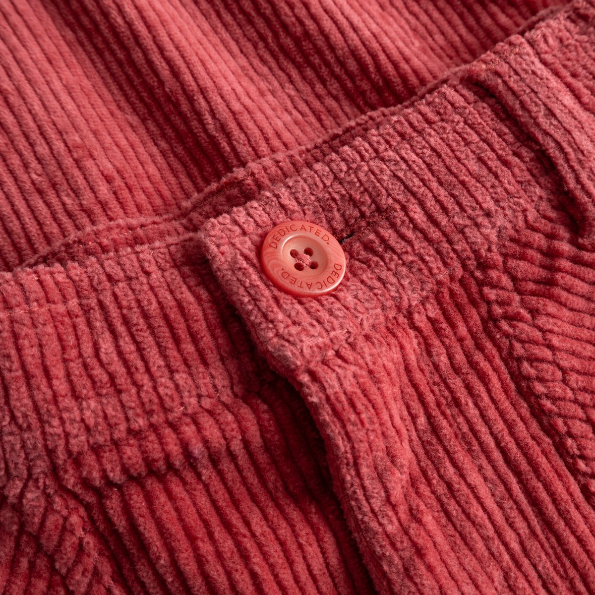 A detailed close-up of the Holly Red Vara Workwear Pants, showcasing the soft corduroy texture and branded button.