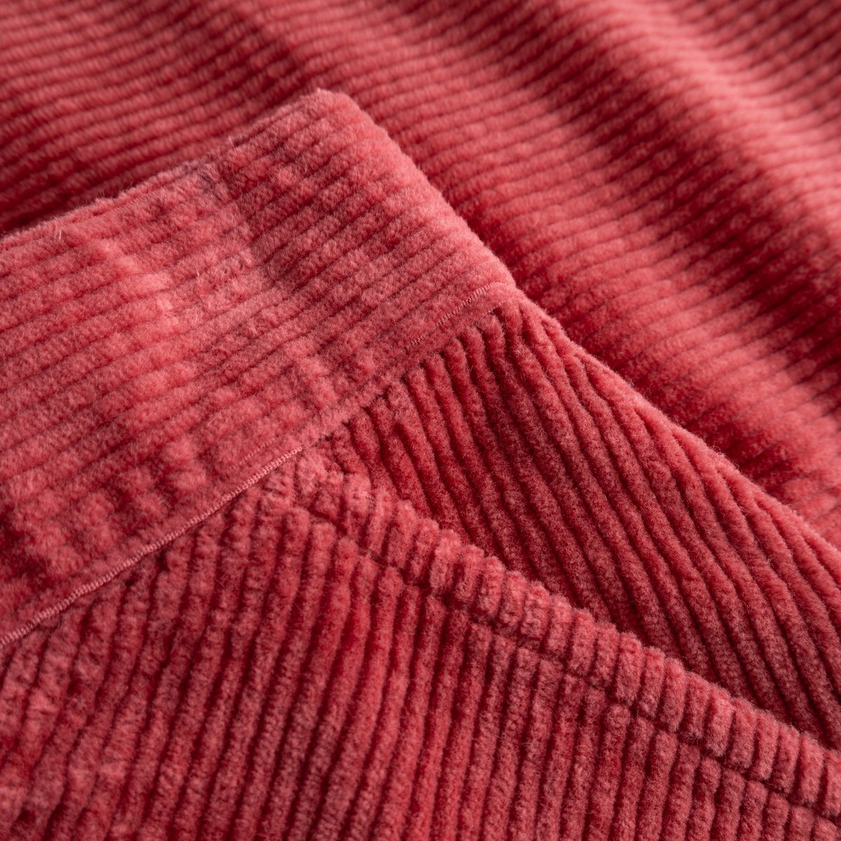 Close-up shot of the soft, ribbed texture of the Skirt Majorna in Holly Red corduroy.