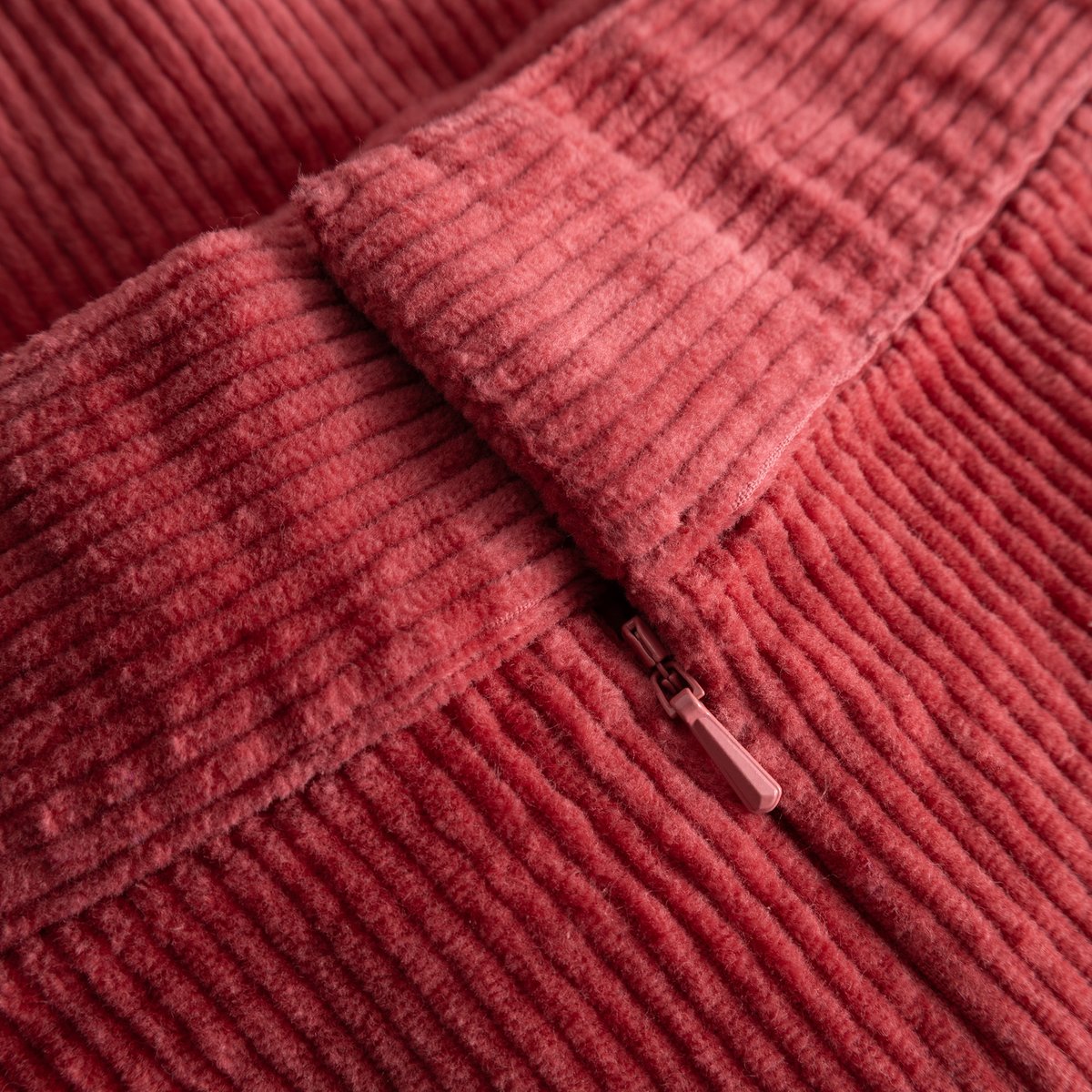 A detailed close-up of the rich corduroy fabric and invisible back zipper on the Majorna Skirt in Holly Red.