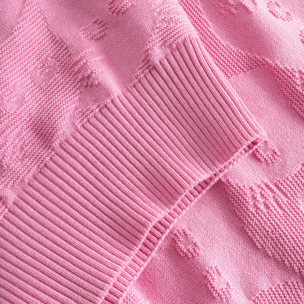 A detailed close-up of the pink Sweater Husie, showcasing the playful Pepita Cats knit pattern and cozy ribbed details.