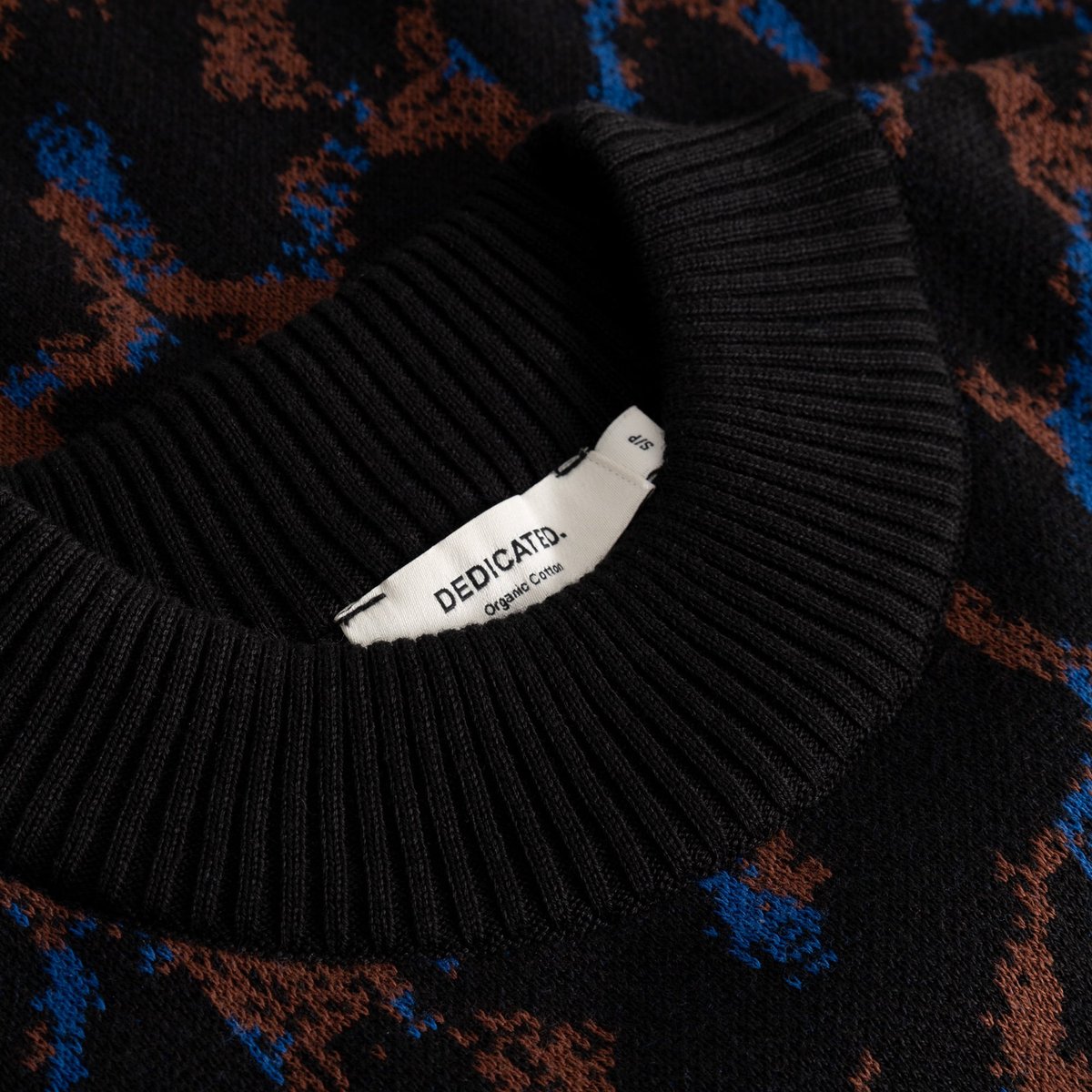 A detailed close-up of the ribbed neckline on the organic cotton Sweater Limhamn, showing off its colorful leopard pattern.