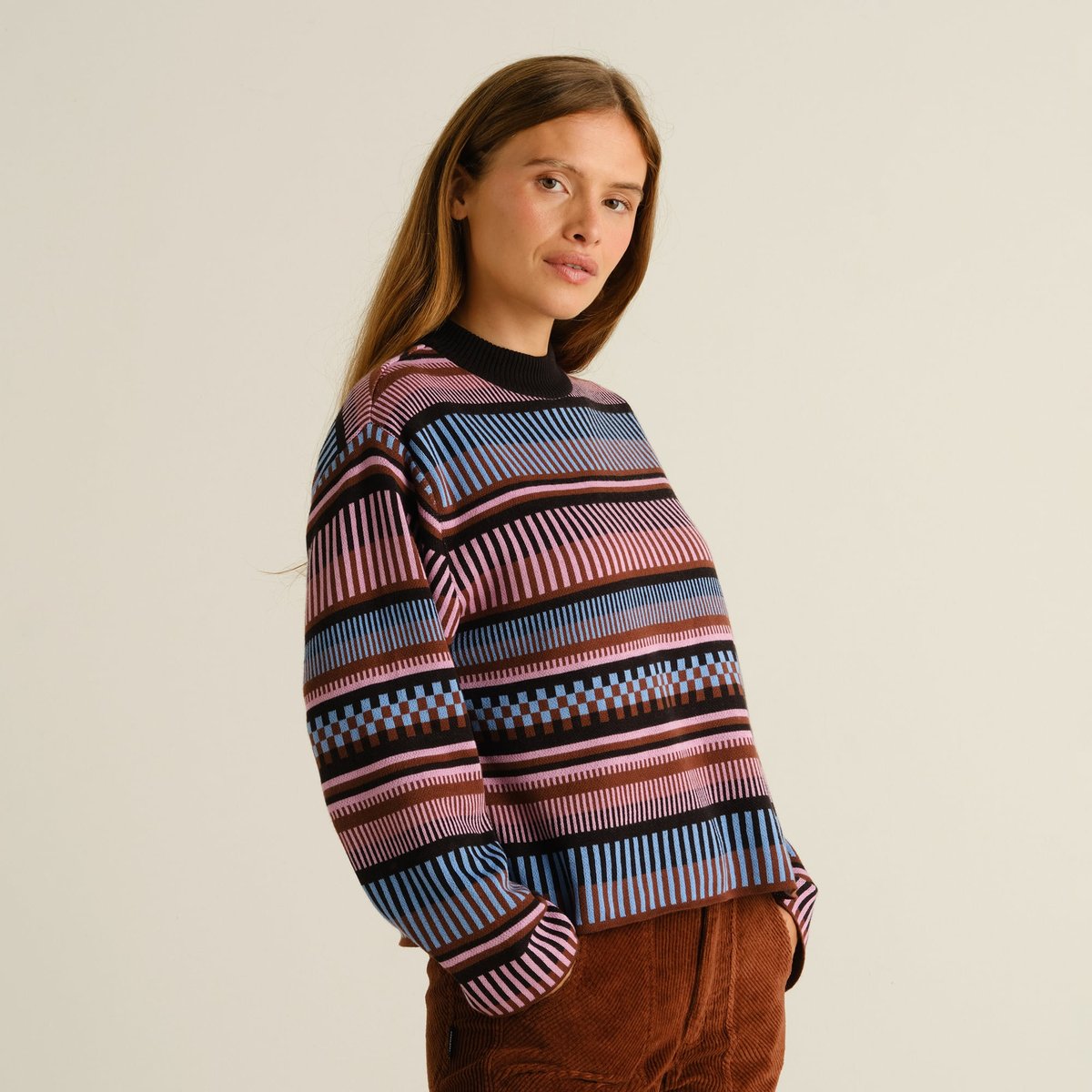 A woman wearing the multi-colored jacquard knit Sweater Limhamn, styled with brown corduroy trousers.