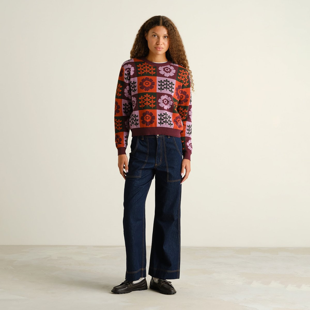 Full-length photo of a model wearing the jacquard-knit Sweater Arendal Nature Check, styled with wide-leg dark denim.