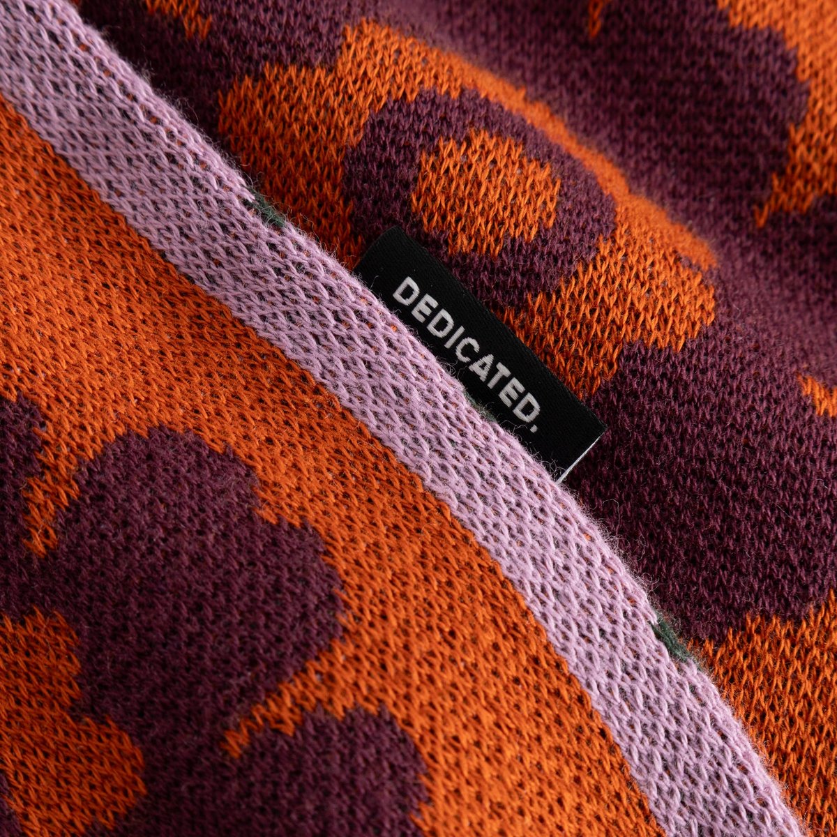 Close-up of the Sweater Arendal in Nature Check, showing the detailed jacquard knit and the black Dedicated brand label.