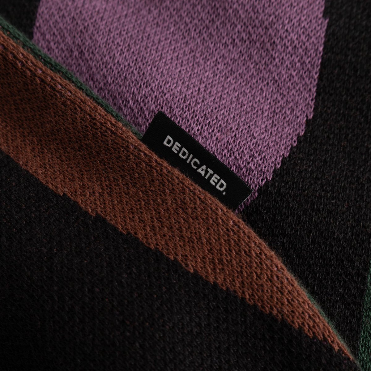 A close-up detail of the Sweater Arendal Wavy Stripe, showing the colorful knit and the classic Dedicated brand label.