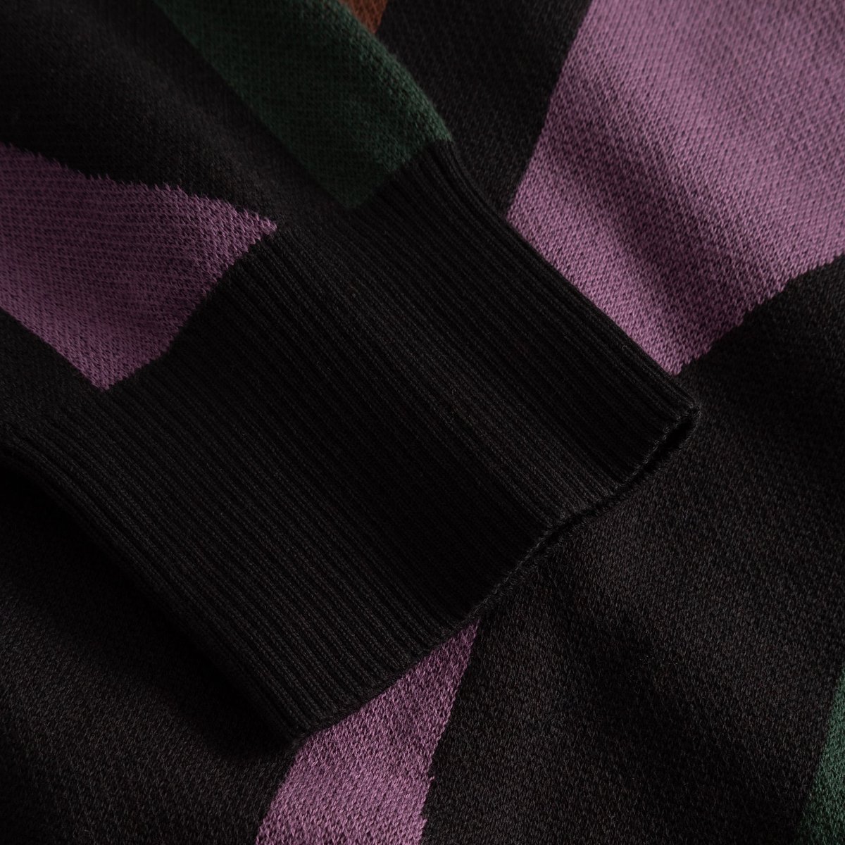 Close-up of the ribbed cuff and colorful wavy knit pattern on the Kanan Cardigan in Multi Color.