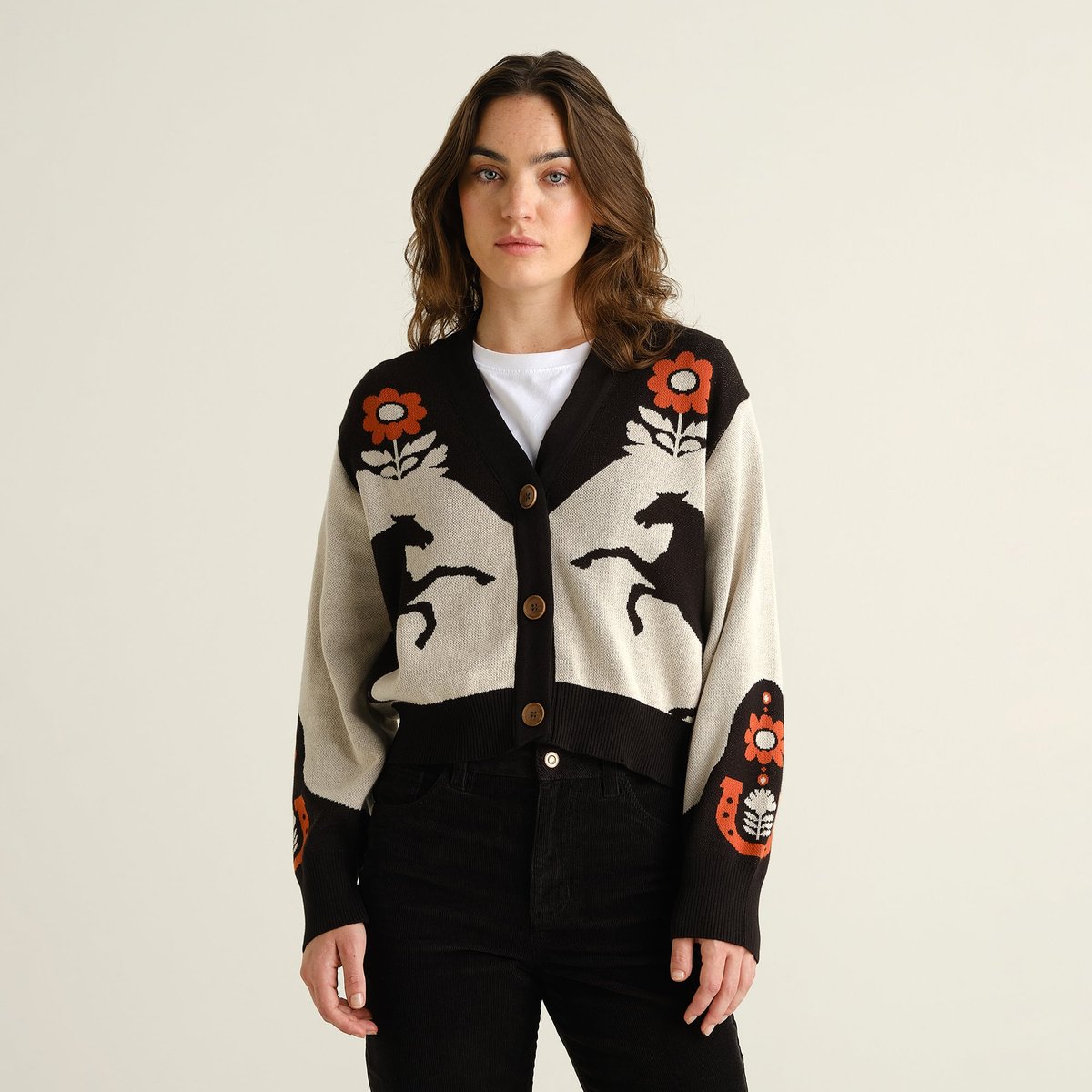 Model wears the Cardigan Kanan Western Multi Color, a knitted V-neck with a unique jacquard pattern of horses and flowers.