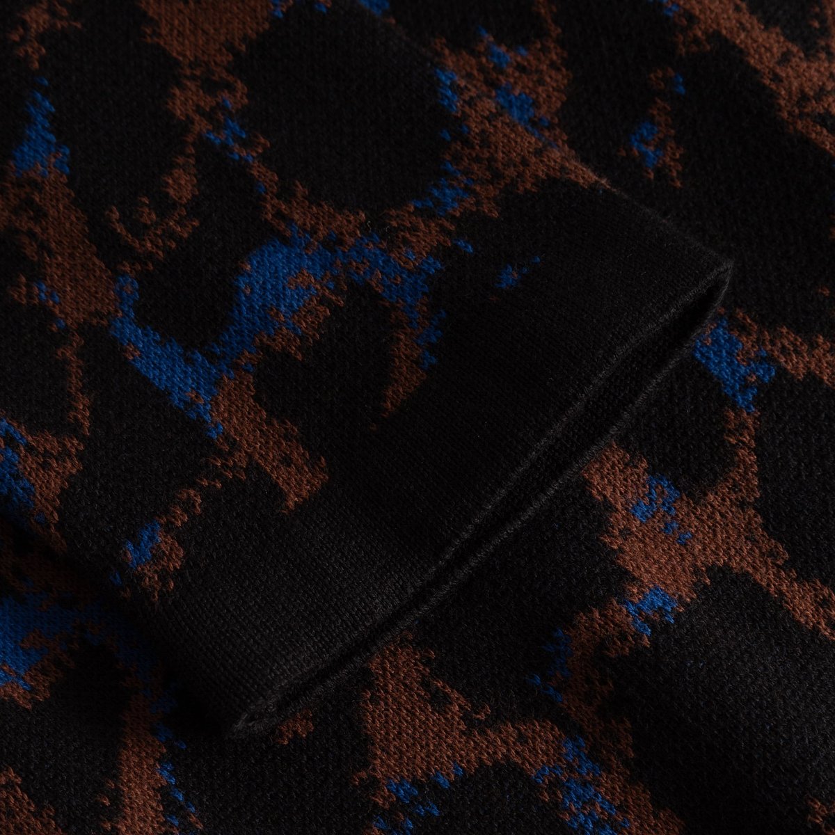Detailaufnahme des gerippten Ärmelbündchens vom Kleid Lo Leopard aus weichem Strick mit mehrfarbigem Muster.