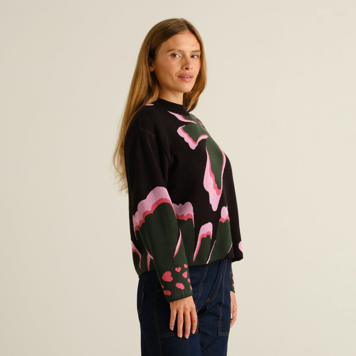 Close-up side view of a woman wearing the Dedicated Sweater Limhamn, featuring the colorful 'Big Bloom' floral pattern.
