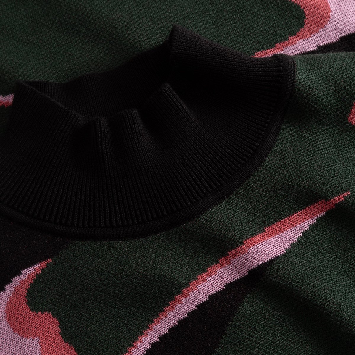 Nahaufnahme des schwarzen Rippkragens des Kleides Nikkala Big Bloom mit Jacquard-Strickmuster in Grün und Pink.