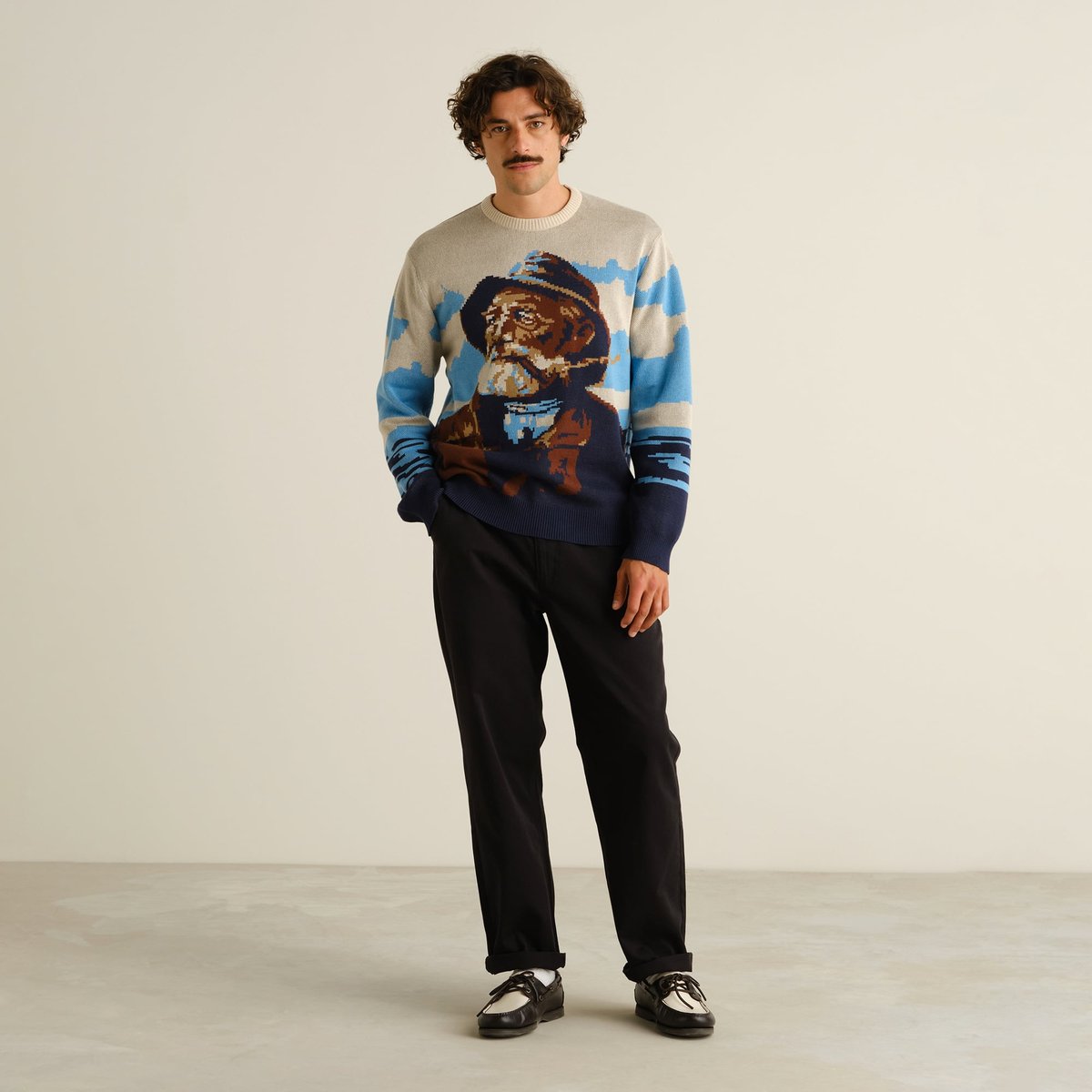 A model creates a cool, retro look with the Sweater Mora Man and Sea, black trousers, and two-tone shoes.