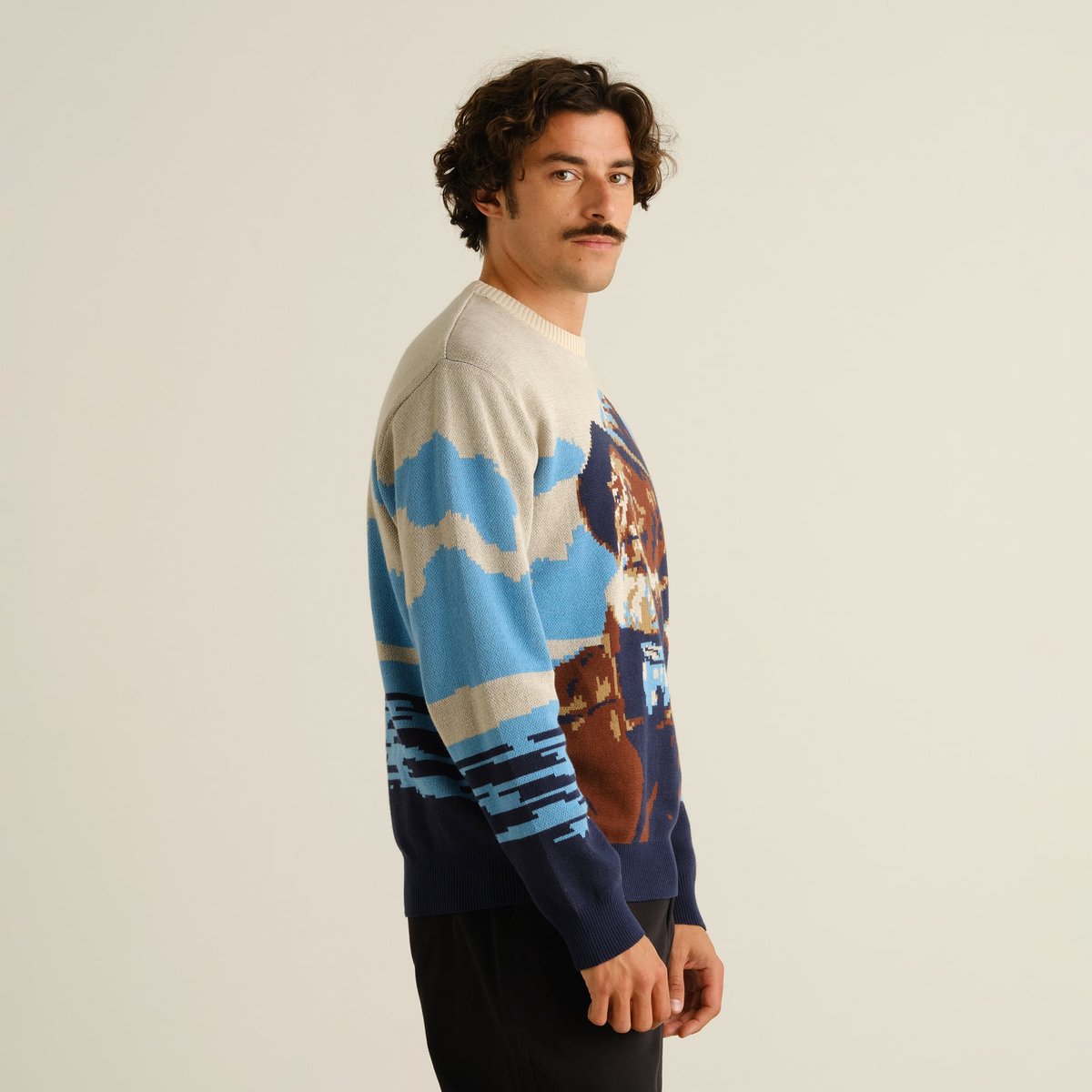 Side view of model wearing Sweater Mora Man and Sea Multi Color, looking back over his shoulder against a plain background.
