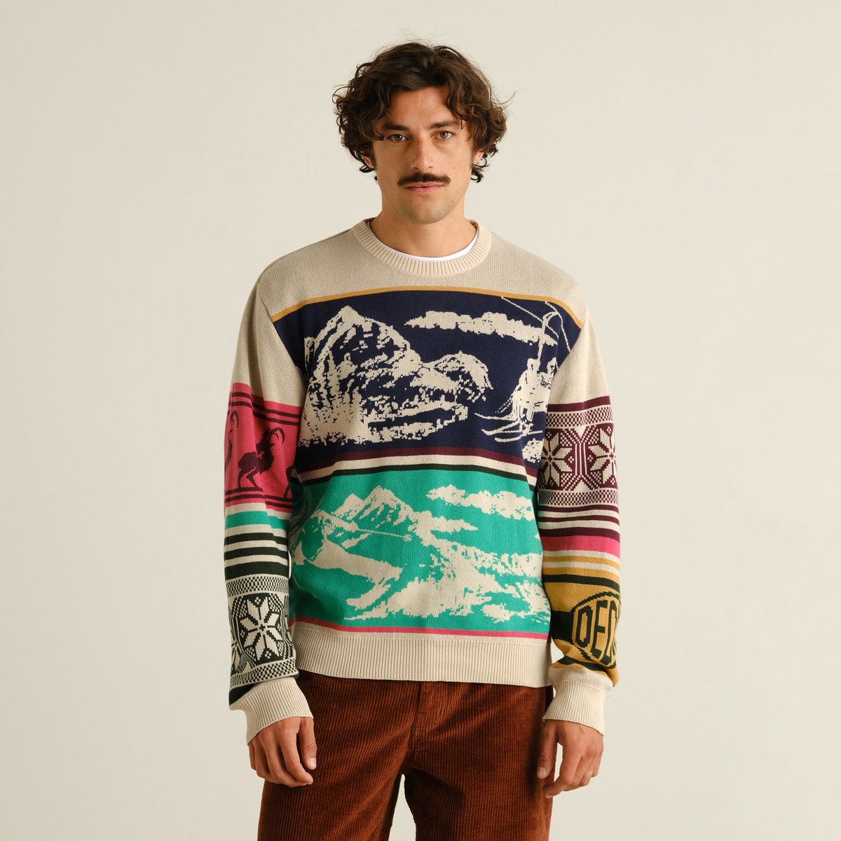 A model wears the Sweater Mora Retro Ski Blocks, a multi-colored jacquard knit with a fun, vintage winter sports pattern.