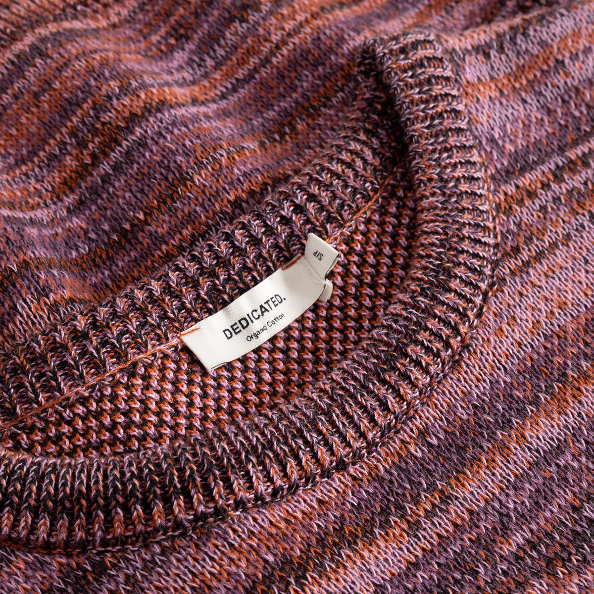 Close-up of the Arendal TY Swan sweater, showing the ribbed neckline and vibrant, multi-colored organic cotton jacquard knit.