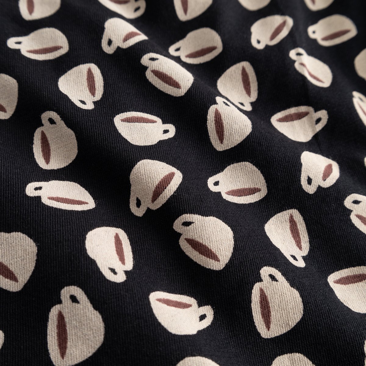 A close-up of the black jersey fabric for the Boxer Briefs Kalix, showing a playful all-over print of coffee cups.
