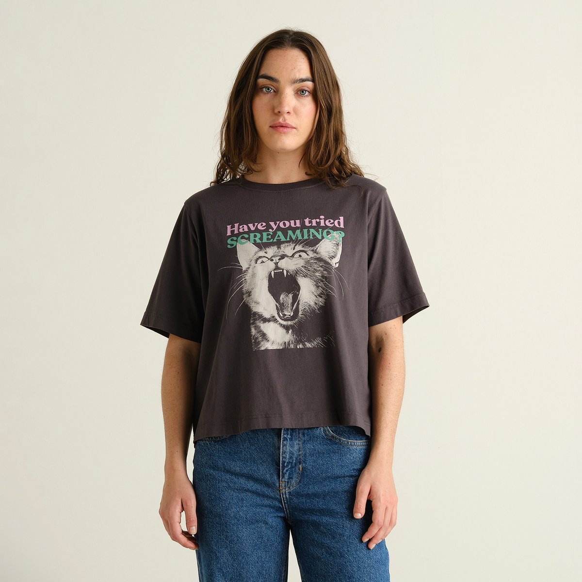 Model wearing the charcoal T-shirt Vadstena with a 'Screaming Cat' print, paired with blue jeans.