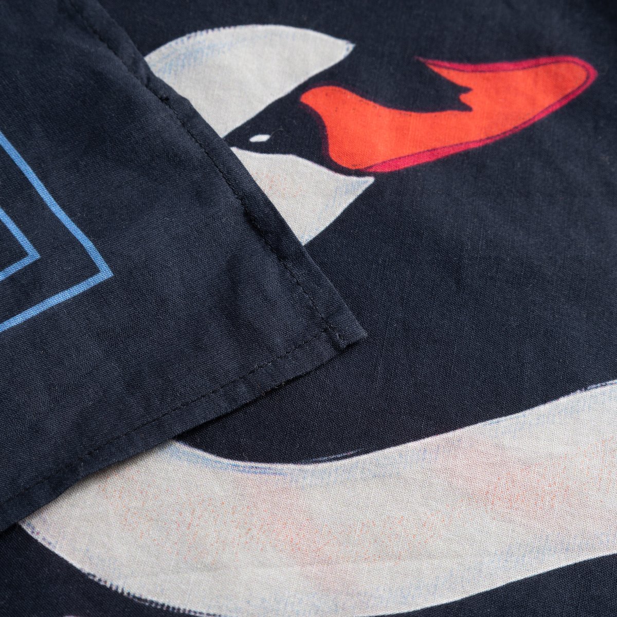 A close-up view of the Scarf Kullavik, highlighting the intricate details of the painted swan graphic and the soft fabric.
