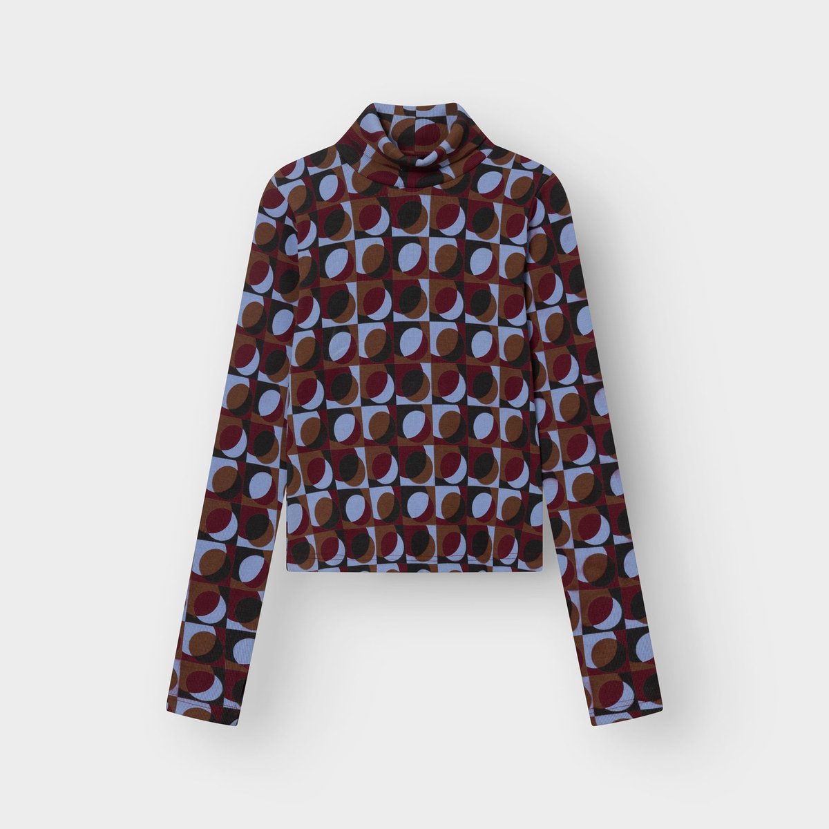 A flat lay product shot of the Rib Top Malma, a turtleneck with a vibrant retro geometric print in multiple colors.