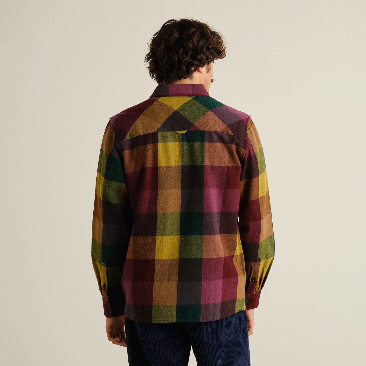 Back view of a man wearing the Dedicated Rute Flannel Shirt in a bold and colorful oversized check pattern.