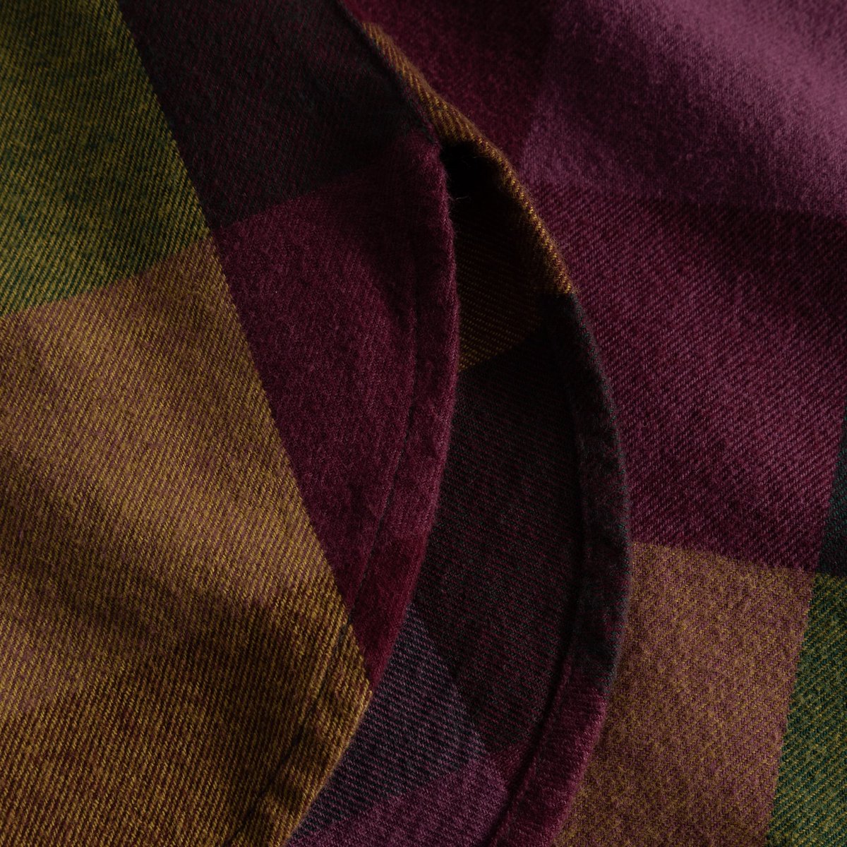 Close-up detail of the Shirt Arboga Flannel, showcasing the soft organic cotton fabric and bold multi-color check pattern.