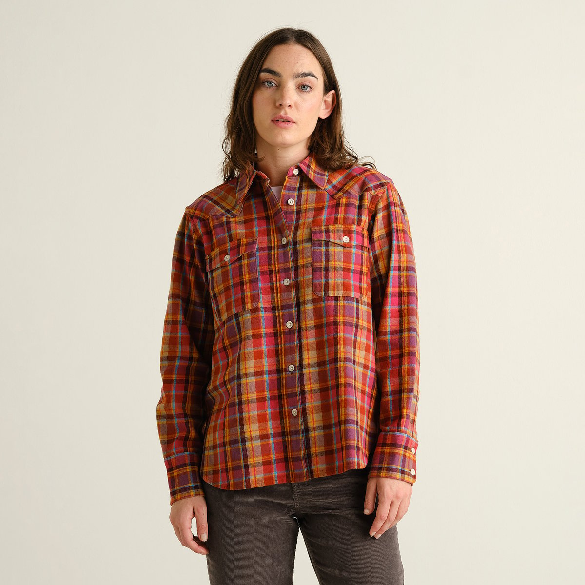 A model shows off the vibrant Shirt Arboga Flannel in Madras Check, styled with dark corduroy pants.