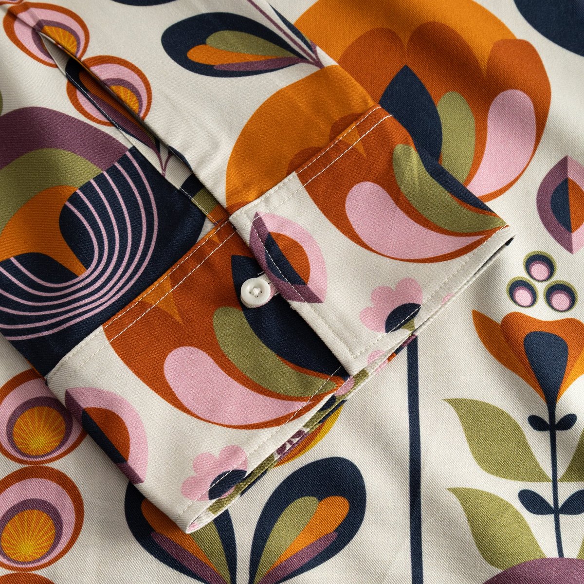 A close-up shot of the buttoned cuff on the Top Udda, showcasing the vibrant and colourful Autumn Harvest print.