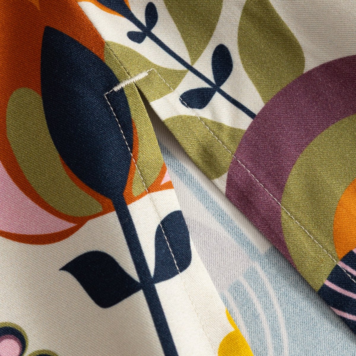 A close-up shot of the fabric on the Skirt Viken, showcasing the detailed stitching and vibrant Autumn Harvest print.