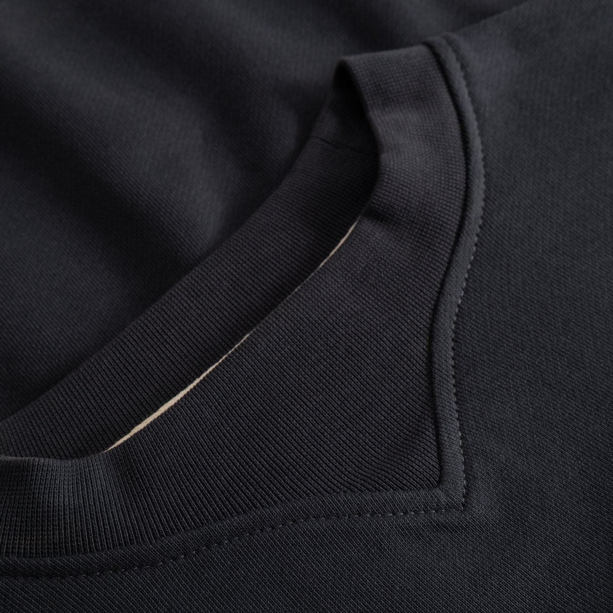 A detailed view of the Sweatshirt Gia in Phantom Black, focusing on the sophisticated V-shaped neck rib and soft texture.