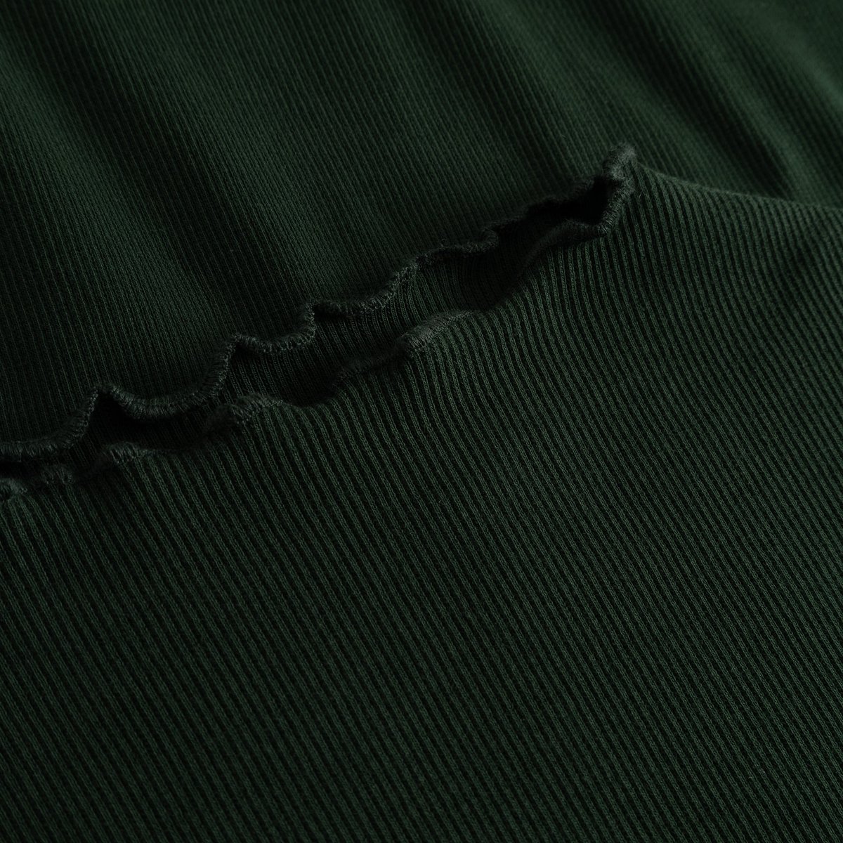 Close-up detail of the Rib Top Ryd in Dark Green, showing the fine ribbing and delicate lettuce-edge seam.