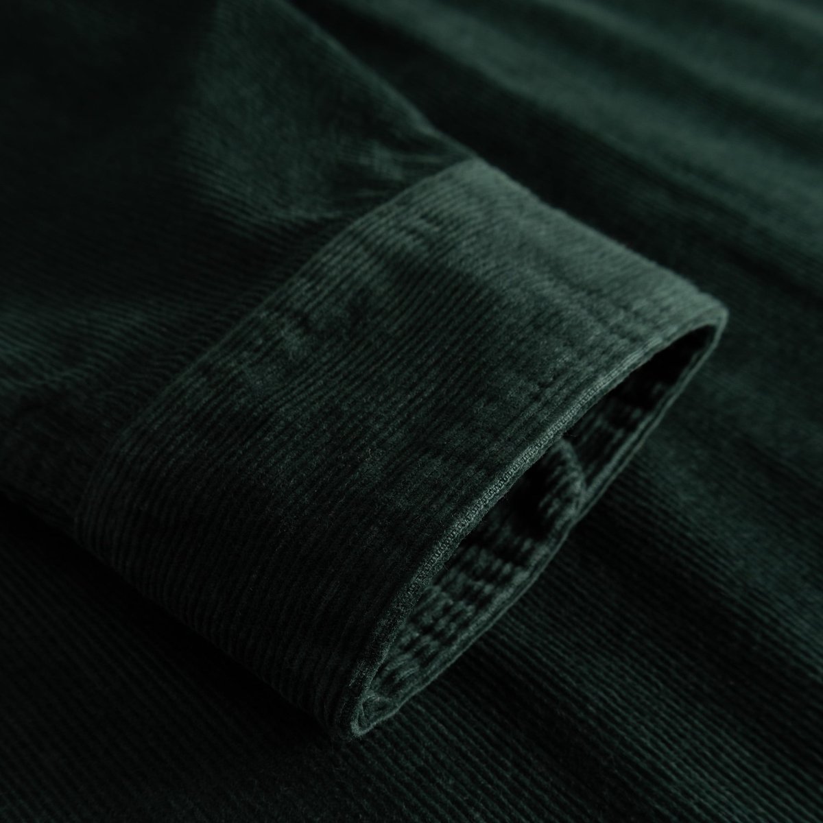 Close-up of the cuff on the Shirt Varberg, showcasing the rich, dark green corduroy fabric.