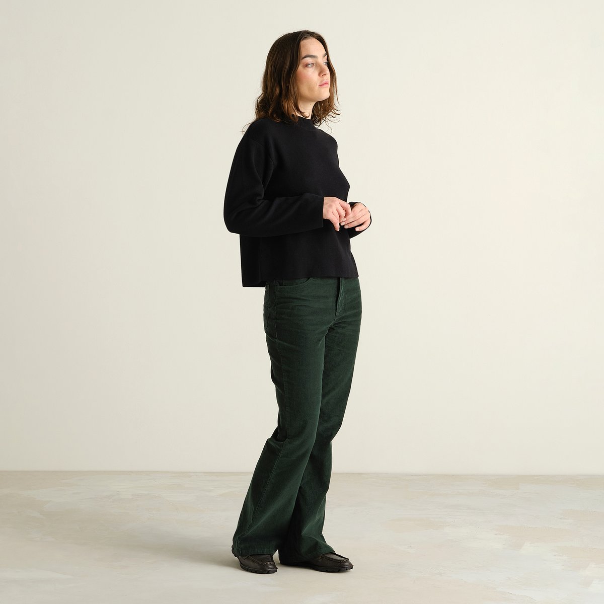 Model looking effortlessly cool in the dark green Ryda Corduroy Pants, styled with a classic black sweater.