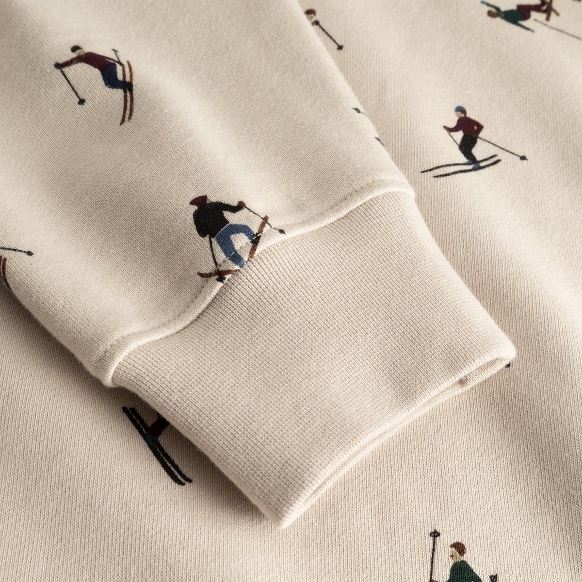 Close-up detail shot of the ribbed cuff and all-over skier print on the oat white Malmoe sweatshirt.