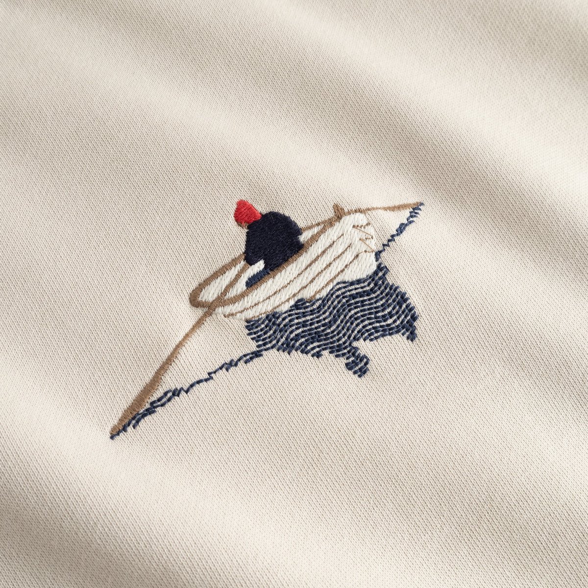 A detailed close-up of the rowing boat embroidery on the chest of the oat white Sweatshirt Malmoe.