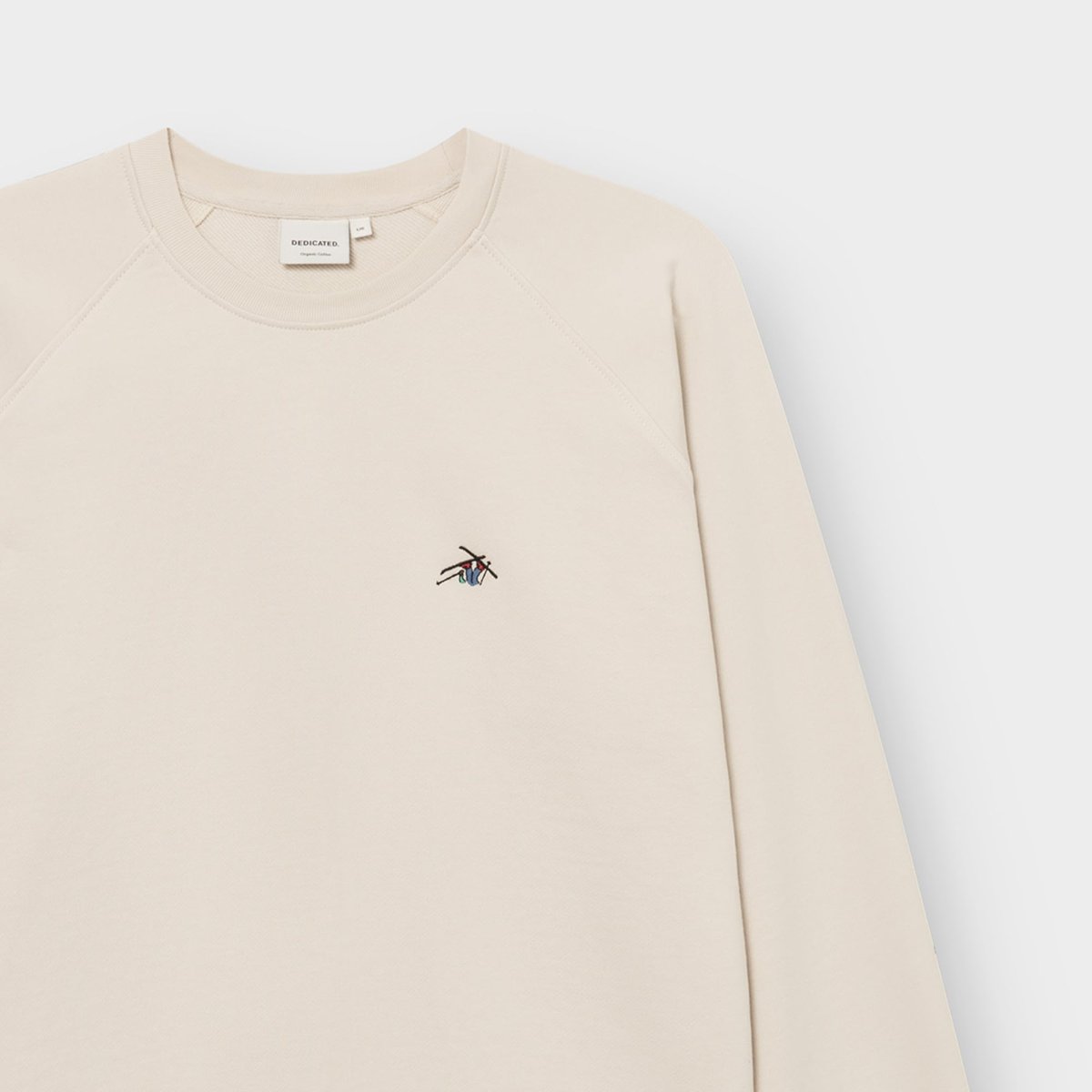 Close-up of the oat white Malmoe sweatshirt, focusing on the neat 'Ski Crash' embroidery on the chest and the crew neck.