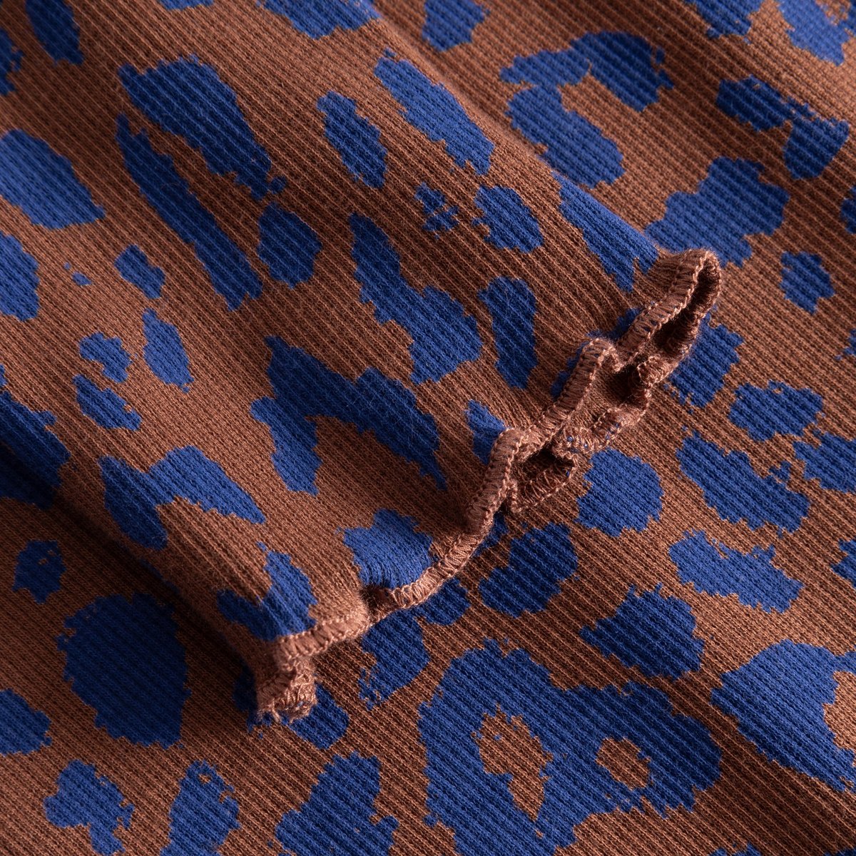 Close-up of the Rib Dress Lofta, showing the brown and blue leopard print on ribbed fabric with a delicate lettuce-edge seam.