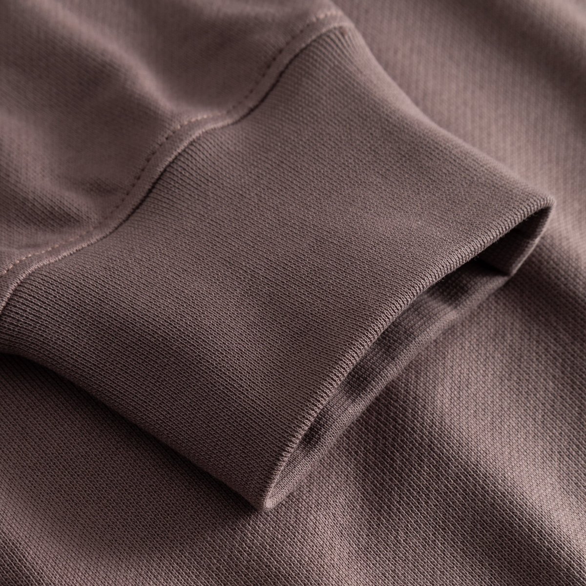 A detailed close-up of the ribbed cuff of the Half Zip Sweatshirt Sandvalla in warm Sparrow Brown.
