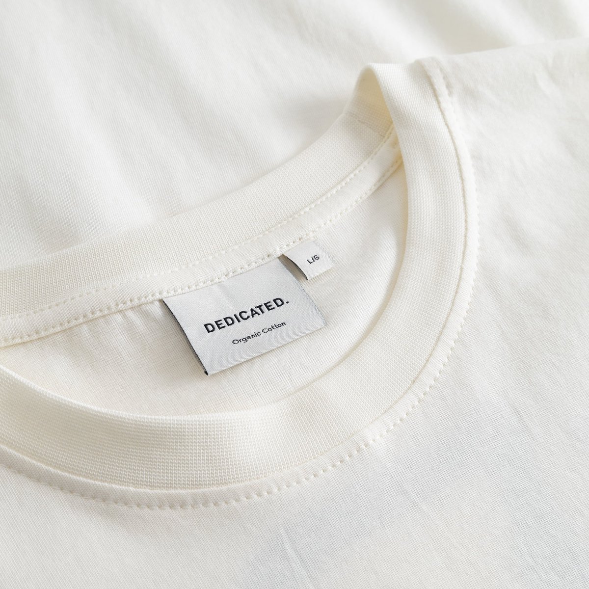 Close-up of the classic ribbed neckline and brand label on the T-shirt Stockholm Painted Side Bike in off-white.