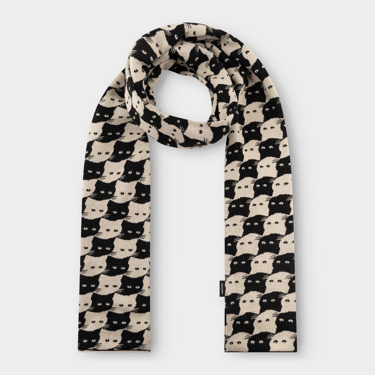 Studio shot of the Rossberga scarf in Oat White, looped to show off its fun, interlocking black and white cat pattern.