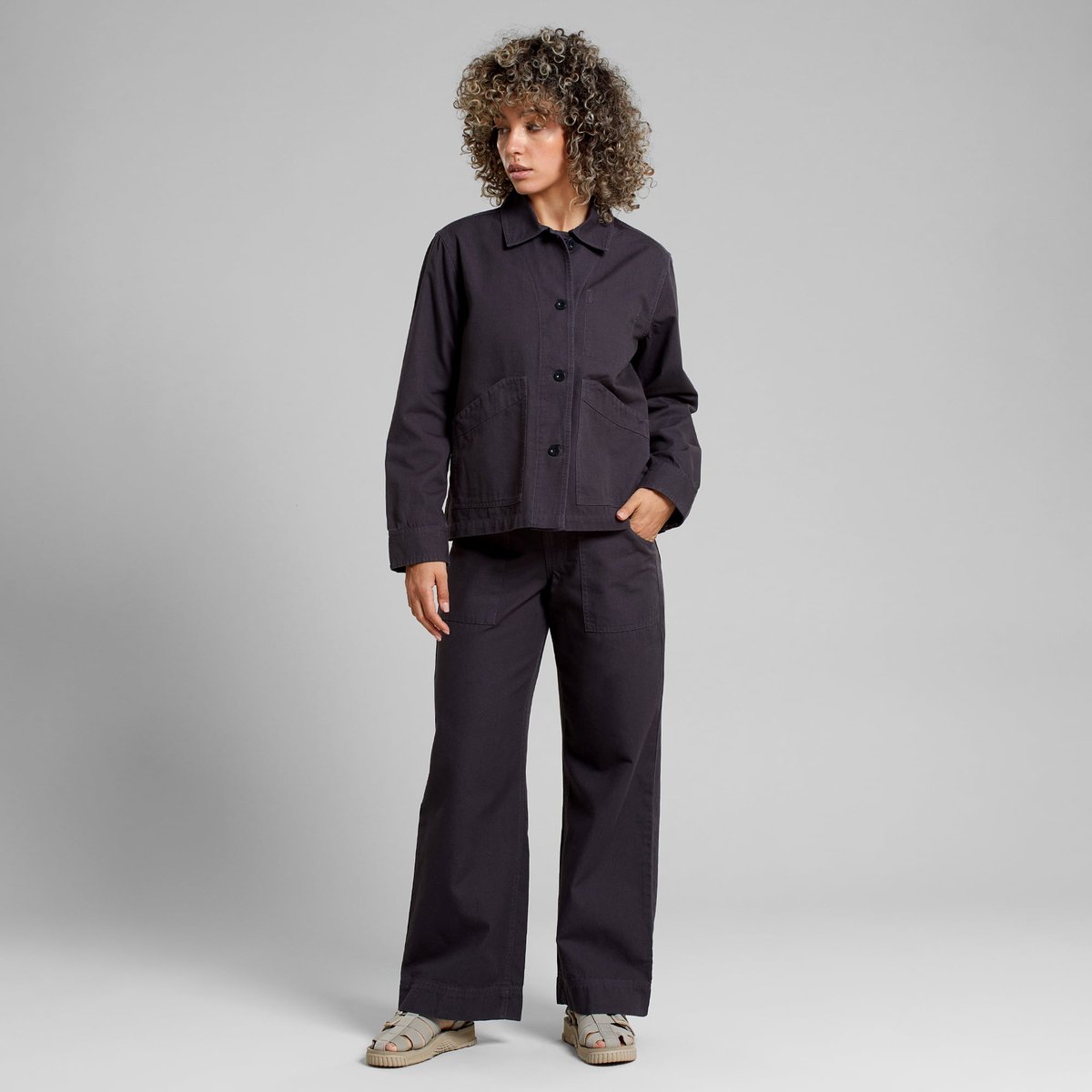 A model wears the relaxed fit Jacket Stiby Canvas in Phantom Black, perfectly paired with matching wide-leg trousers.