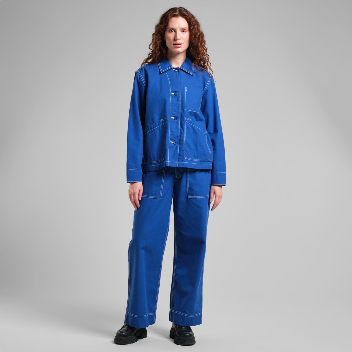 Model wearing the relaxed-fit Stiby Canvas Jacket in Surf Blue with matching trousers, shown in a full-length studio shot.