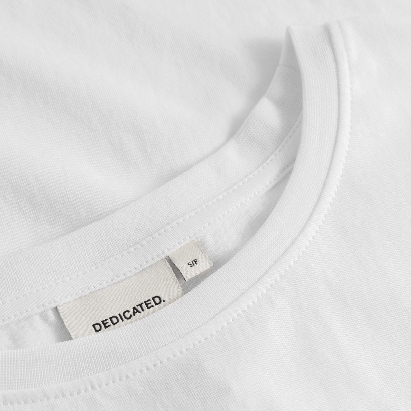 Detail shot of the T-shirt Visby Pizza Love in white, focusing on the ribbed crew neck and the Dedicated brand label.