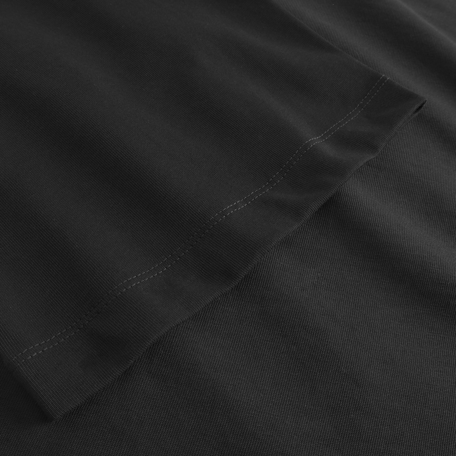 A close-up detail shot of the T-shirt Ljusdal in black, showing the quality of the heavy organic cotton jersey fabric.