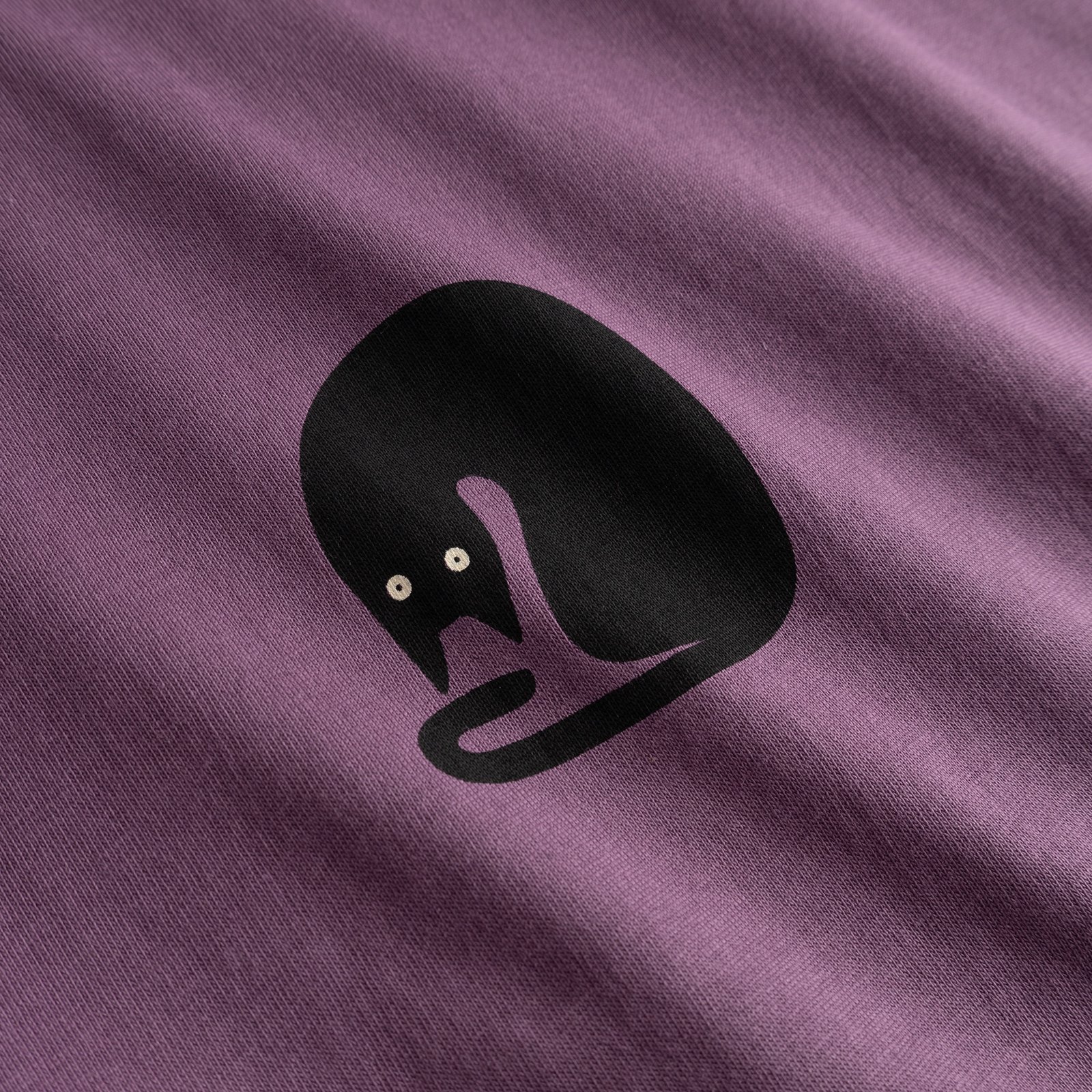 Detailed shot of the fun 'Curious Cat' graphic on the berry purple T-shirt Visby.