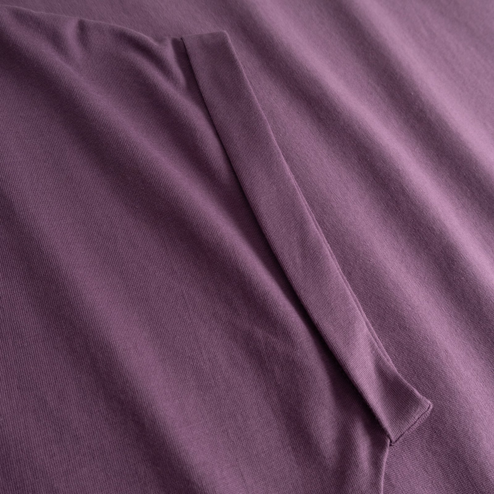 A detailed look at the folded sleeve of our T-shirt Visby Base in Berry Purple, crafted from soft organic cotton.